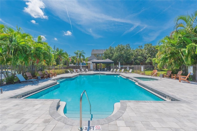 view of swimming pool with a patio area and a hot tub