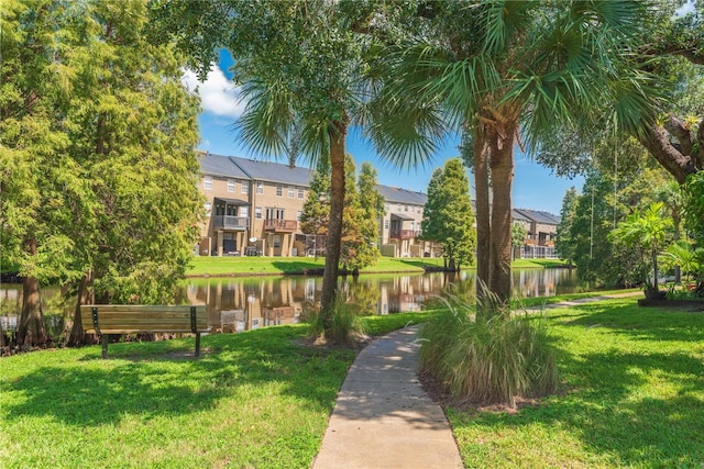 view of property's community with a lawn and a water view