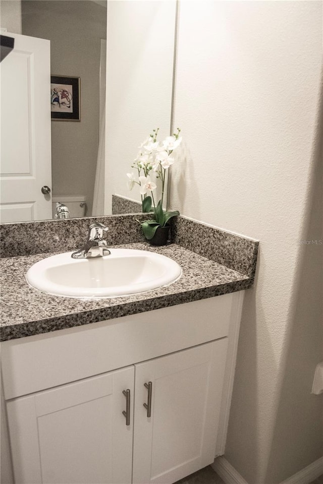 bathroom featuring vanity and toilet