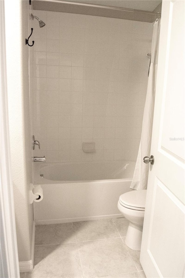 bathroom with shower / bath combination with curtain, toilet, and tile patterned floors