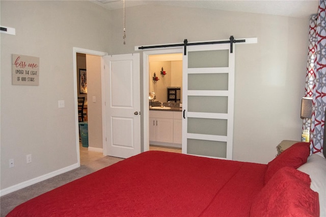 carpeted bedroom featuring vaulted ceiling, ensuite bathroom, and a barn door