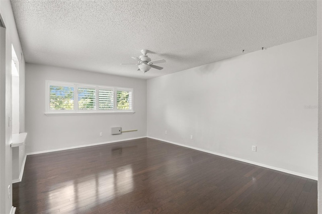 empty room with ceiling fan, dark hardwood / wood-style floors, and a textured ceiling