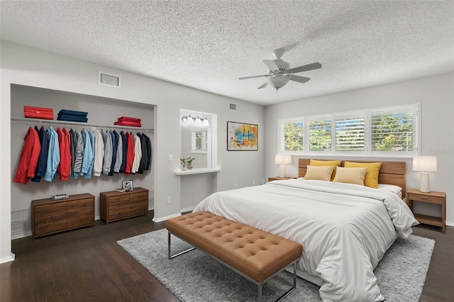 bedroom featuring ceiling fan, dark hardwood / wood-style floors, a textured ceiling, and a closet