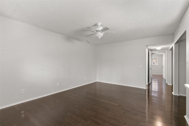 spare room featuring dark wood-type flooring, a textured ceiling, and ceiling fan