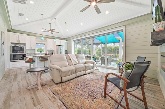 living room featuring light hardwood / wood-style floors, wood walls, vaulted ceiling with beams, ceiling fan, and wooden ceiling