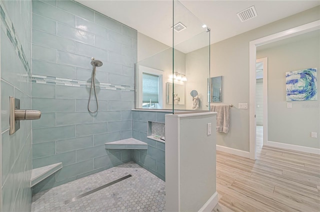 bathroom featuring a tile shower and hardwood / wood-style floors