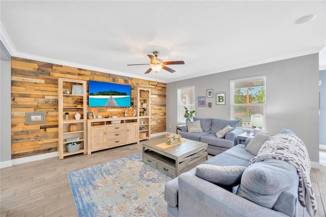 living room with wood walls, light wood-type flooring, crown molding, ceiling fan, and built in shelves