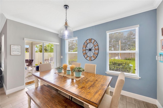 dining area featuring ornamental molding and light hardwood / wood-style flooring