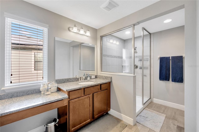 bathroom with wood-type flooring, walk in shower, and vanity