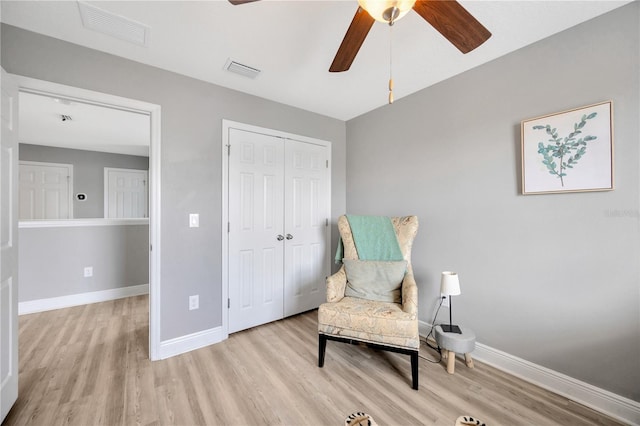 living area featuring light wood-type flooring and ceiling fan