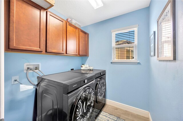 laundry room featuring cabinets and washer and dryer