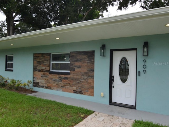 property entrance with a lawn