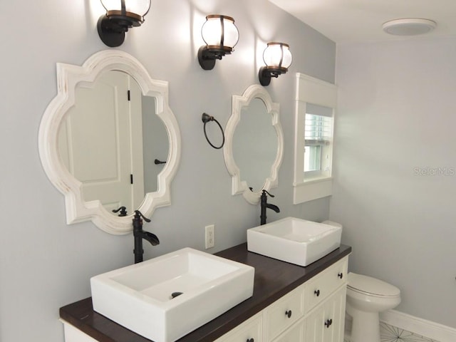 bathroom featuring tile patterned flooring, vanity, and toilet