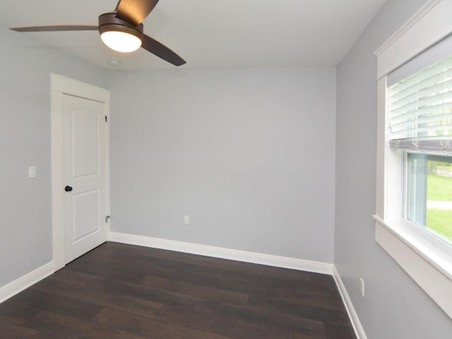 empty room featuring ceiling fan, plenty of natural light, and dark hardwood / wood-style flooring