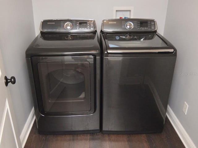 clothes washing area featuring separate washer and dryer and dark wood-type flooring