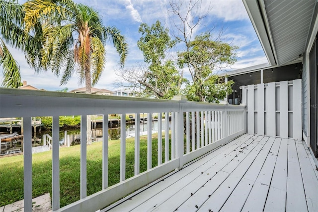 deck with a yard and a water view