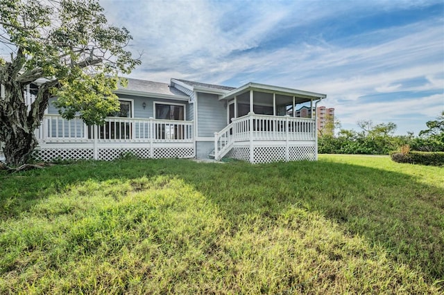 ranch-style house featuring a sunroom, a front yard, and a deck