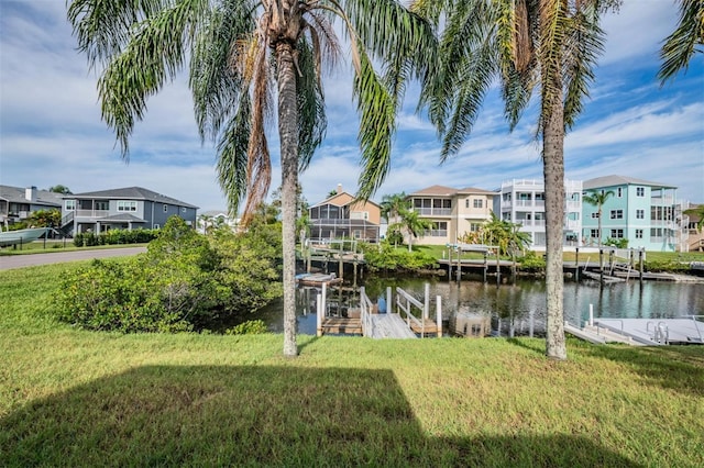 dock area featuring a water view and a lawn