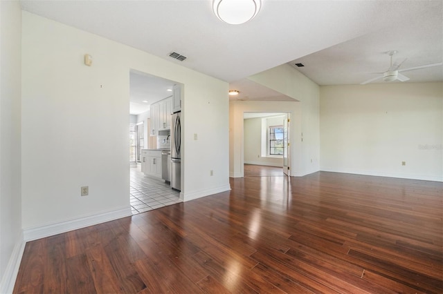 empty room with ceiling fan, wood-type flooring, and a healthy amount of sunlight