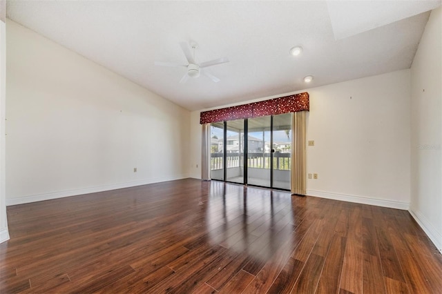 empty room featuring ceiling fan, dark hardwood / wood-style floors, and vaulted ceiling