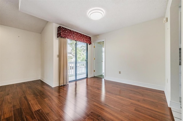 spare room with dark wood-type flooring and a textured ceiling