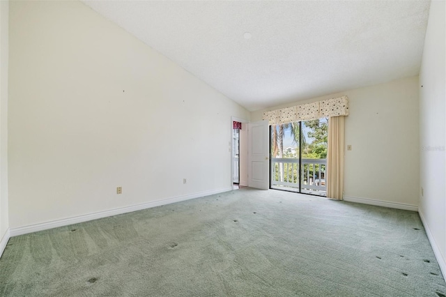 carpeted empty room with vaulted ceiling and a textured ceiling