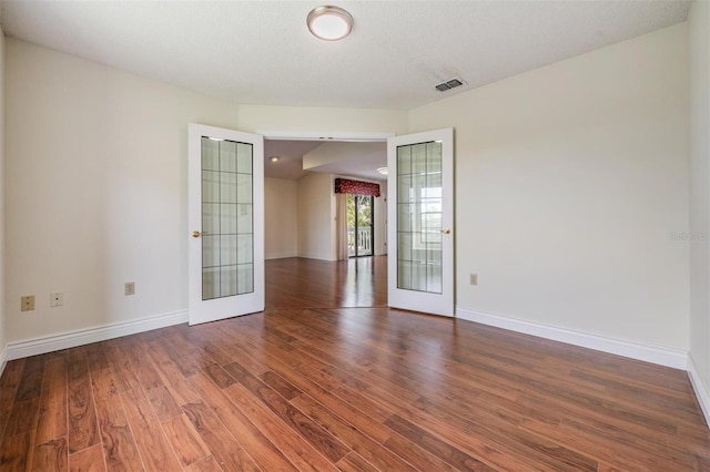 empty room featuring french doors and dark hardwood / wood-style flooring