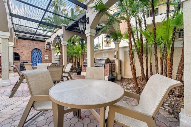 view of patio featuring exterior kitchen, glass enclosure, and area for grilling