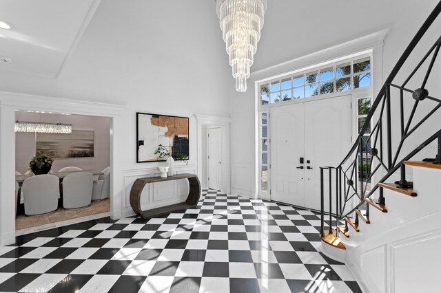 45 Adalia Ave, Tampa, FL 33606 - foyer entrance featuring a high ceiling, a chandelier, stairs, a decorative wall, and tile patterned floors