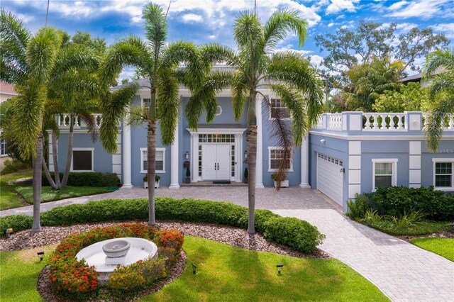 45 Adalia Ave, Tampa, FL 33606 - view of front of home with an attached garage, decorative driveway, stucco siding, and a front yard