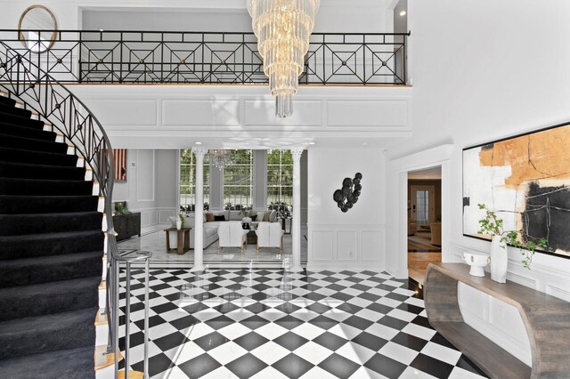 45 Adalia Ave, Tampa, FL 33606 - entryway featuring a decorative wall, stairway, a chandelier, a towering ceiling, and a wainscoted wall