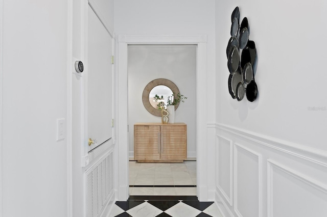 45 Adalia Ave, Tampa, FL 33606 - hallway featuring inlaid floor details, wainscoting, a decorative wall, and tile patterned floors
