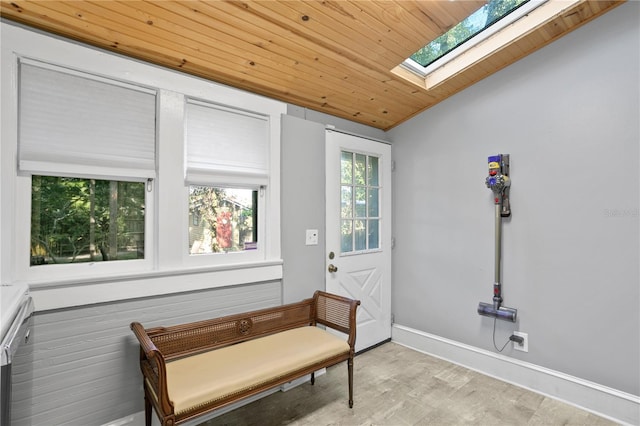 living area featuring vaulted ceiling with skylight, wooden ceiling, and light hardwood / wood-style floors