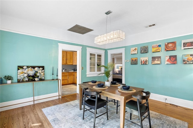 dining space featuring hardwood / wood-style flooring and a chandelier