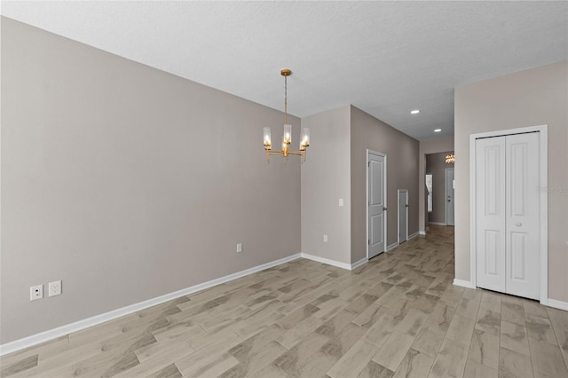 interior space featuring a chandelier, light hardwood / wood-style floors, and a textured ceiling