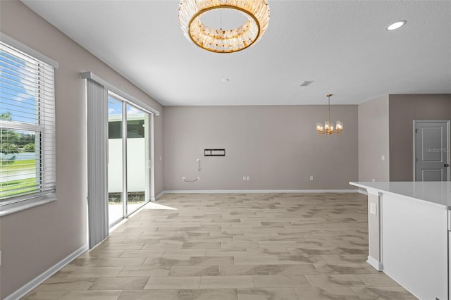 unfurnished room featuring an inviting chandelier