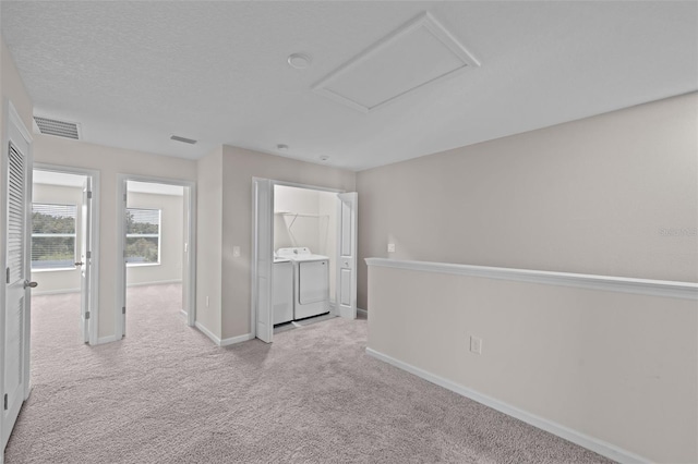 unfurnished room with light colored carpet and washing machine and dryer