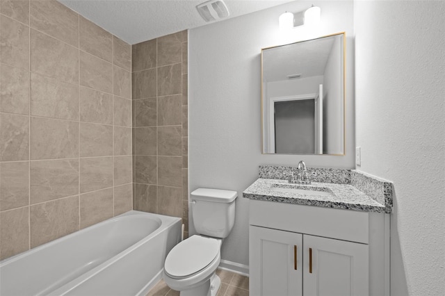 bathroom featuring a textured ceiling, vanity, and toilet