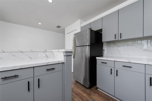 kitchen with stainless steel refrigerator, dark hardwood / wood-style floors, and gray cabinets