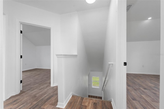 stairway featuring hardwood / wood-style flooring and vaulted ceiling