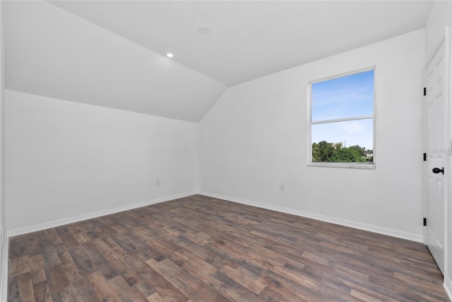 additional living space with vaulted ceiling and dark hardwood / wood-style floors