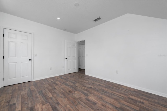 unfurnished room featuring a textured ceiling, lofted ceiling, and dark hardwood / wood-style flooring