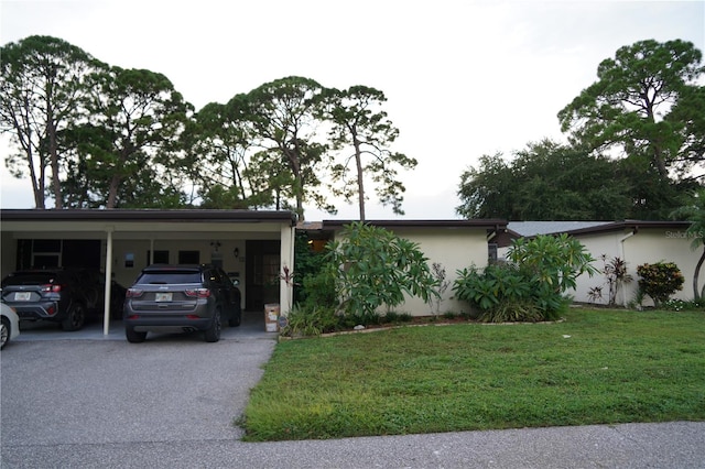 ranch-style home featuring a front lawn and a carport