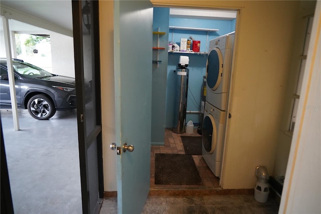 clothes washing area featuring stacked washer and clothes dryer