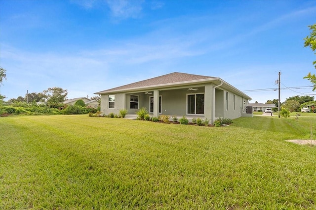 10061 Gulfstream Blvd, Englewood, FL 34224 - rear view of house featuring ceiling fan, a lawn, and stucco siding