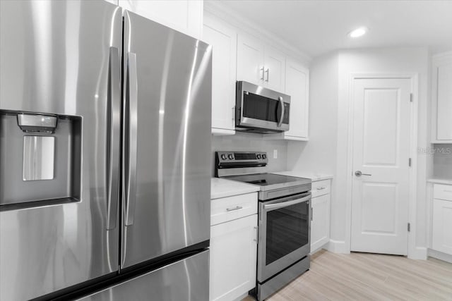 10061 Gulfstream Blvd, Englewood, FL 34224 - kitchen featuring appliances with stainless steel finishes, white cabinetry, light countertops, light wood-style flooring, and recessed lighting