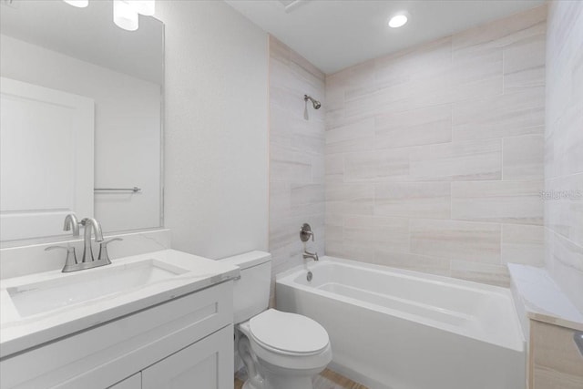 full bathroom featuring tiled shower / bath combo, vanity, and toilet