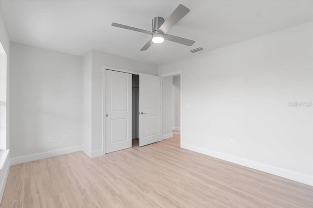 unfurnished bedroom featuring light wood-type flooring, ceiling fan, and a closet