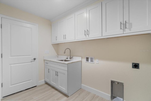 washroom featuring washer hookup, hookup for an electric dryer, cabinets, sink, and light hardwood / wood-style flooring