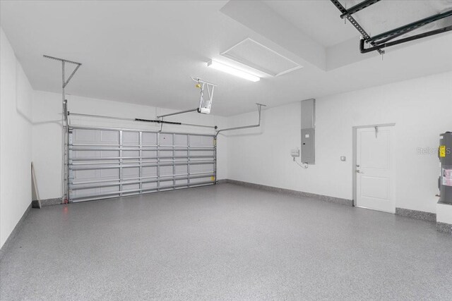 10061 Gulfstream Blvd, Englewood, FL 34224 - garage with electric panel, baseboards, a garage door opener, and water heater